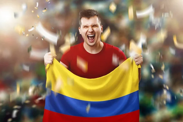 Un fan colombiano, un fan de un hombre con una bandera nacional colombiana en sus manos. Aficionado al fútbol en el estadio. Medios mixtos — Foto de Stock