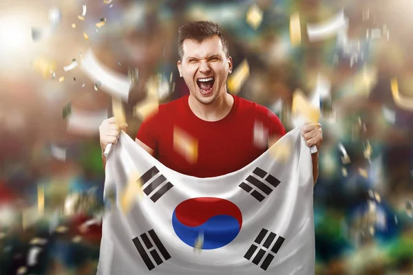 Abanico surcoreano, un fan de un hombre con la bandera nacional de Corea del Sur en sus manos. Aficionado al fútbol en el estadio. Medios mixtos —  Fotos de Stock