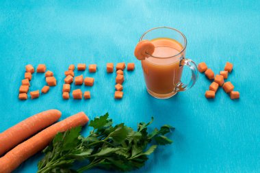 Yazıt Detoks, üstten görünüm, mavi bir arka plan üzerine bir bardak havuç suyu. Sağlıklı bir diyet, diyet kavramı.
