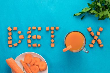 Yazıt Detoks, üstten görünüm, mavi bir arka plan üzerine bir bardak havuç suyu. Sağlıklı bir diyet, diyet kavramı.