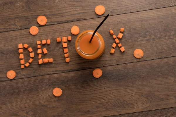 Aufschrift Detox, Karottensaft im Glas auf Holzgrund, Draufsicht. Konzept der gesunden Ernährung, Rohkost-Ernährung, Ernährung. — Stockfoto