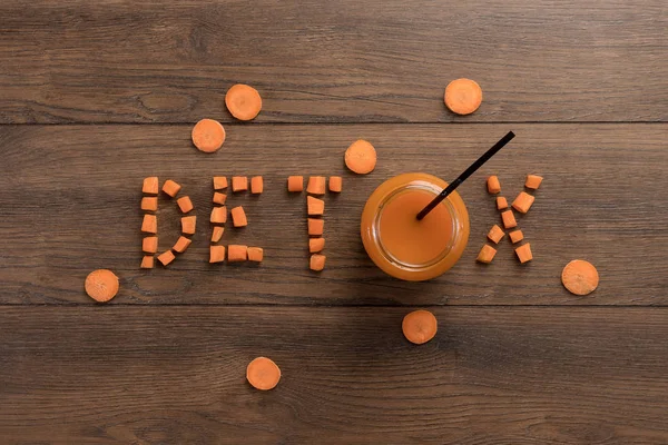 Aufschrift Detox, Karottensaft im Glas auf Holzgrund, Draufsicht. Konzept der gesunden Ernährung, Rohkost-Ernährung, Ernährung. — Stockfoto