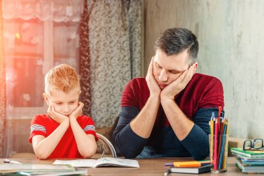Baba oğlu ödev yapmak için yardımcı olur.