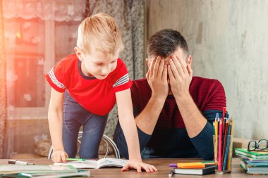 Baba oğlu ödev yapmak için yardımcı olur.