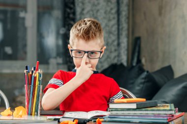 Küçük çocuk okulun ödevlerini yapıyor. Eğitim, çalışma