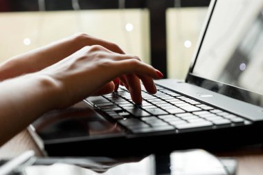 yakın çekim Ofis Masası. Çalışma alanı ile kızın eller, dizüstü bilgisayar, kahve fincanı. İş kadını.