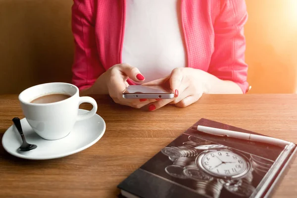 黒電話、クローズ アップ、一杯のコーヒー、テーブル、ノートの背景を持つ女性の手。ビジネス ランチ. — ストック写真