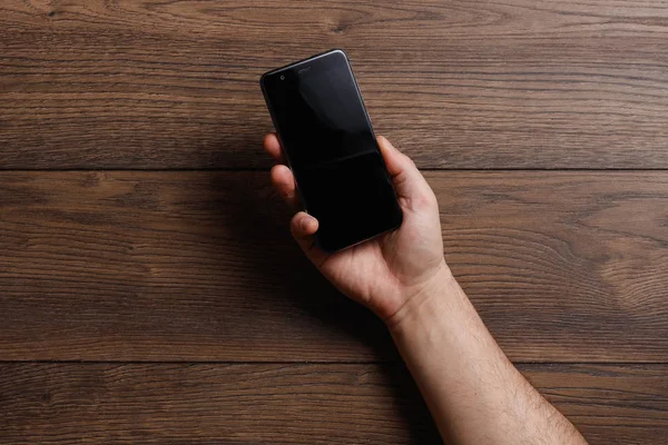 Female hands using a smartphone on a wooden table. copy space — Stock Photo, Image