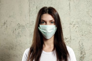 kadın kahverengi saçlı ve koruma için tıbbi maske tekrar grip. Sığ derinlik-in tarla. Metniniz için kopya alanı.