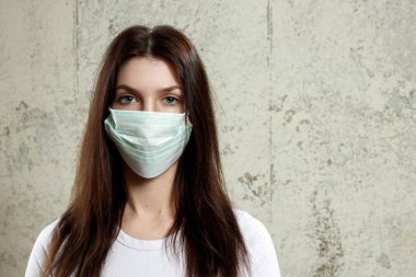 kadın kahverengi saçlı ve koruma için tıbbi maske tekrar grip. Sığ derinlik-in tarla. Metniniz için kopya alanı.