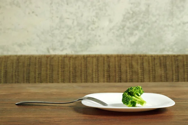 Foto der Gabel mit weißem Teller und Brokkoli auf Holztisch. das Konzept einer gesunden Ernährung, Entgiftung, Gewichtsabnahme, Ernährung, Essstörungen, Magersucht, Bulimie. — Stockfoto