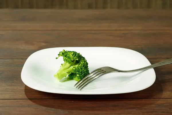 Foto della forchetta con piastra bianca e broccoli sul tavolo in legno. Il concetto di una dieta sana, disintossicazione, perdita di peso, dieta, problemi alimentari, anoressia, bulimia . — Foto Stock