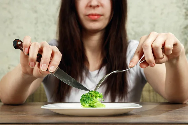 Triste joven morena que trata con anorexia nerviosa o bulimia que tiene pequeña verdura verde en el plato. Problemas de dieta, trastorno alimentario . — Foto de Stock