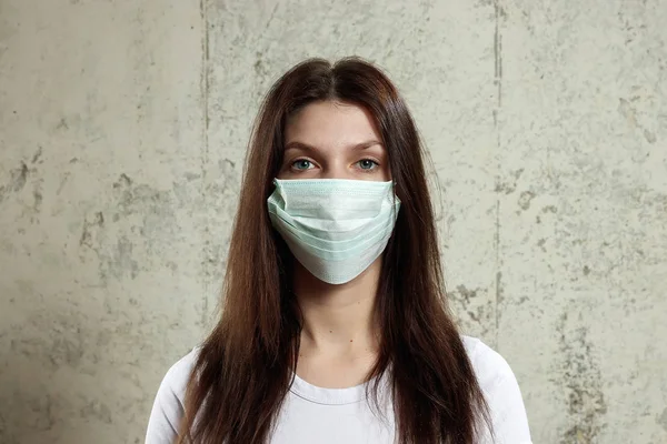 woman with brown hair and a medical mask for protection again influenza. Shallow depth of field. Copy space for your text.