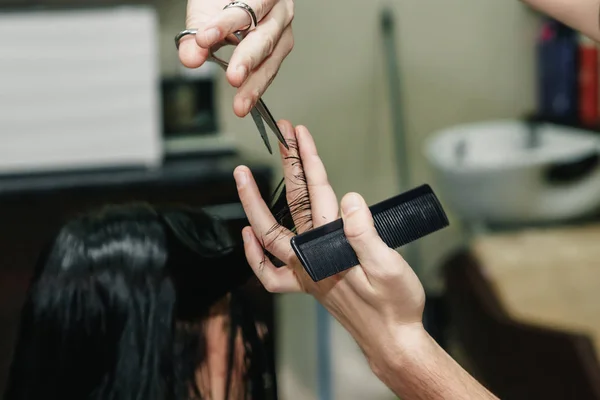 Крупним планом перукарня, що ріже волосся жінки в салоні краси — стокове фото