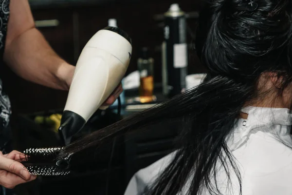 Secagem de cabelo castanho longo com secador de cabelo e escova redonda. Close-up. — Fotografia de Stock
