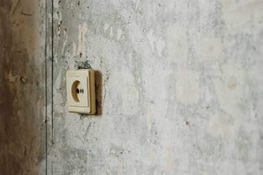 Yaşlı, sarı bir rozet gri beton duvara. Onarım