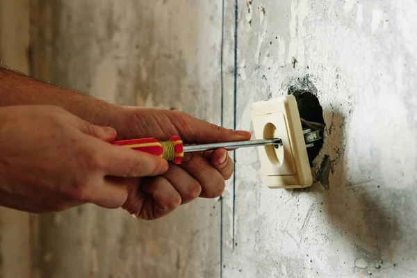 Close-up Of Person\'s Hand Installing Socket On Wall At Home