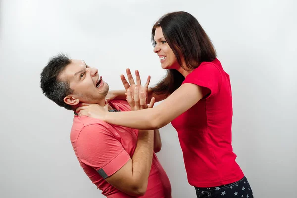 Querelle de famille, sa femme gronde son mari, une jeune et belle femme étrangle son mari. Le concept de psychologie des relations familiales, du mariage, des conflits familiaux, de la violence domestique . — Photo