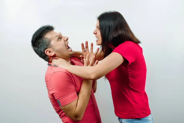 Querelle de famille, sa femme gronde son mari, une jeune et belle femme étrangle son mari. Le concept de psychologie des relations familiales, du mariage, des conflits familiaux, de la violence domestique . — Photo