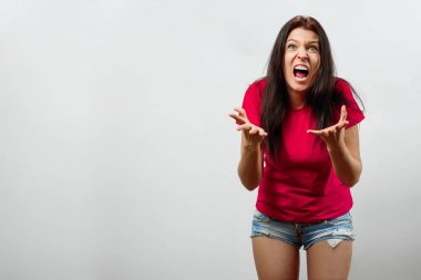 Genç, güzel bir kız ile bir şey mutlu değil, çığlık attı. Hafif bir arka plan üzerinde izole. Farklı insan duyguları, yüz ifadesi, tutum, algı, beden dili, tepki duyguları