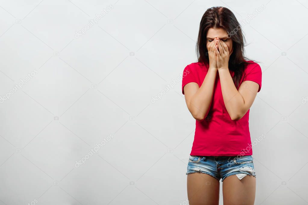 A young, beautiful girl covers her nose, a bad smell. Isolated on a light background. Different human emotions, feelings of facial expression, attitude, perception, body language, reaction.