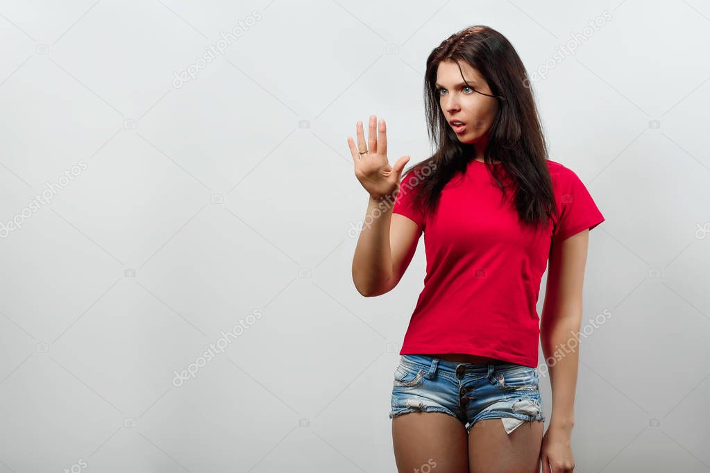 A young, beautiful girl admires the manicure. Isolated on a light background. Different human emotions, feelings of facial expression, attitude, perception, body language, reaction.