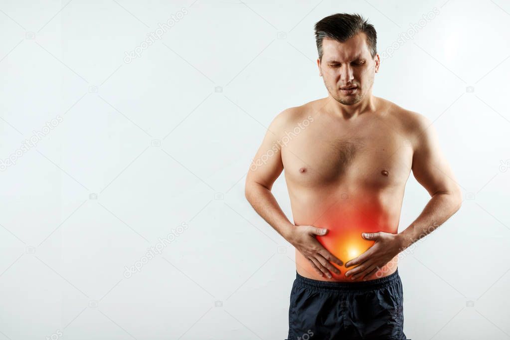 Front view, the man holds his hands to the stomach, abdominal pain, pain in the stomach highlighted in red. Light background. The concept of medicine, massage, physiotherapy, health.