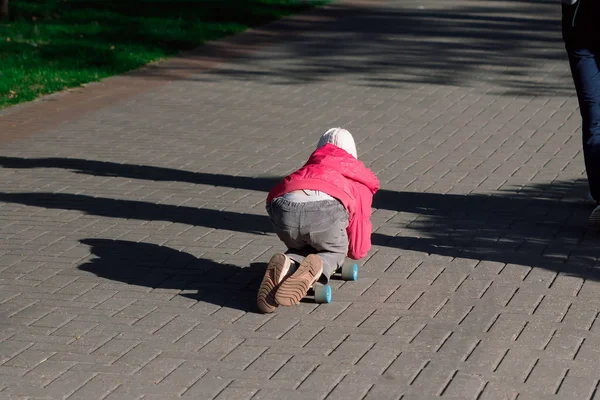 Little girl skateboard rijdt op de straten van de stad op skateboard. Kinder sport. — Stockfoto