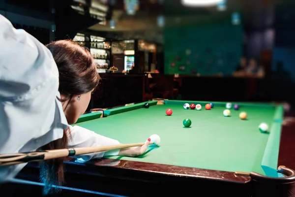 Genç güzel kız bilardo oynuyor. Karanlık arka plan. Keyifli zaman geçirme, dinlenme, eğlence. — Stok fotoğraf