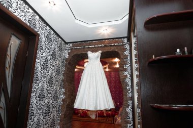 Kompozisyon: Gri mavi bir duvarda, dekorlu ve aksesuarlı bir gelinlik. Evlilik kavramı, aile ilişkileri, düğün aletleri..