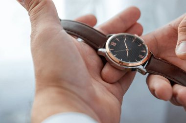 Bir iş adamının elleri, yakın plan, saatin düğmeleri.