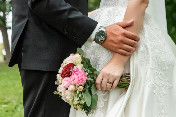 Série de casamento 25. Buquê de casamento de rosas coloridas na mão da noiva . — Fotografia de Stock