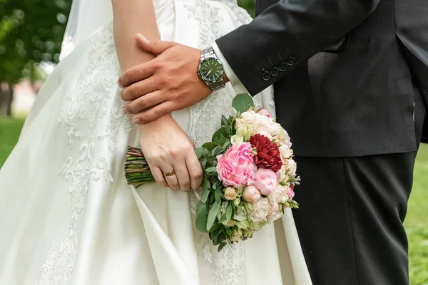 Série de casamento 25. Buquê de casamento de rosas coloridas na mão da noiva . — Fotografia de Stock