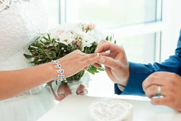 De bruid en bruidegom wisselingen, close-up. Het concept van het huwelijk, familierelaties, bruiloft parafernalia. — Stockfoto