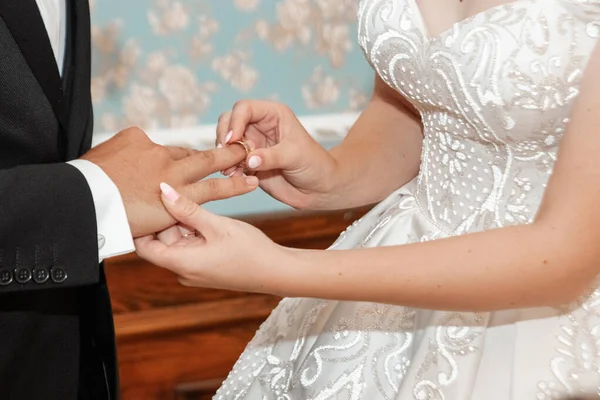 De bruid en bruidegom wisselingen, close-up. Het concept van het huwelijk, familierelaties, bruiloft parafernalia. — Stockfoto