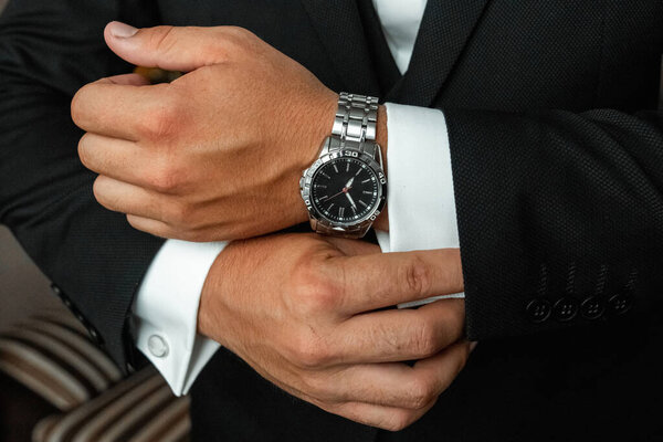 Hands of a businessman, close-up, buttons on a watch