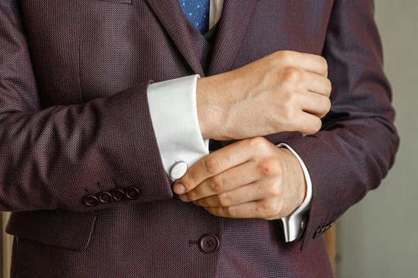 Handen van een zakenman, close-up, knoopmouwen op een shirt. — Stockfoto