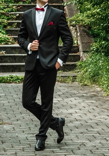 Novio vestido con un traje elegante posando sobre un fondo de calle . — Foto de Stock