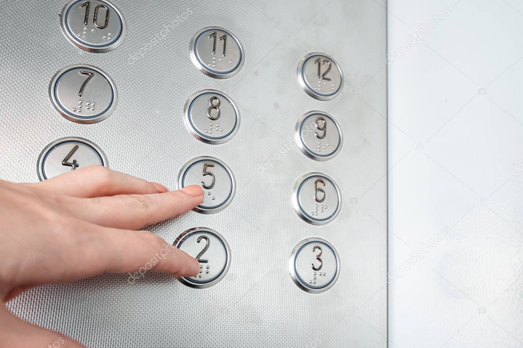 Female hand, finger presses the elevator button. up the career ladder.