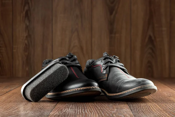 Μαύρα παπούτσια ένα καθαρό δεύτερο βρώμικο σε ξύλινο φόντο. Η έννοια της λάμψης παπουτσιών, της φροντίδας ρούχων, των υπηρεσιών. — Φωτογραφία Αρχείου