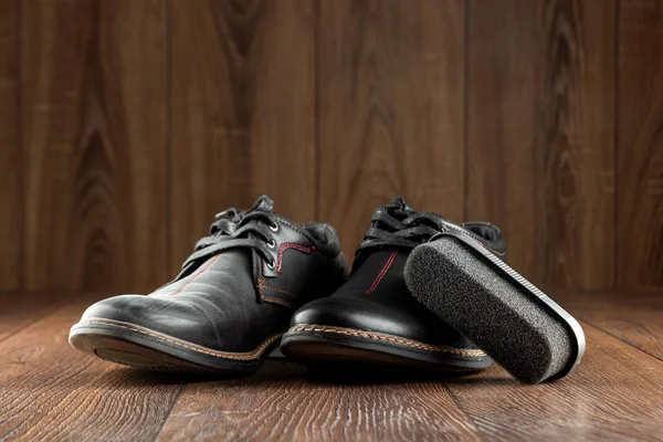 Μαύρα παπούτσια ένα καθαρό δεύτερο βρώμικο και βούρτσα σε ξύλινο φόντο. Η έννοια της λάμψης παπουτσιών, της φροντίδας ρούχων, των υπηρεσιών. — Φωτογραφία Αρχείου