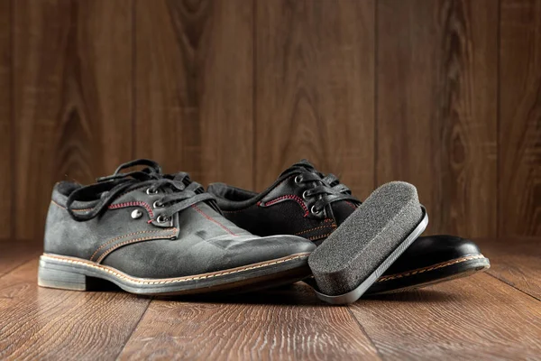 Μαύρα παπούτσια ένα καθαρό δεύτερο βρώμικο και βούρτσα σε ξύλινο φόντο. Η έννοια της λάμψης παπουτσιών, της φροντίδας ρούχων, των υπηρεσιών. — Φωτογραφία Αρχείου