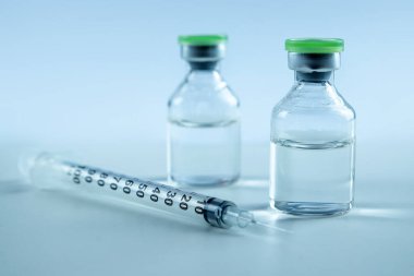 Vaccine in vial and syringe close-up on a white table gray background, medical concept, laboratory, subcutaneous injection vaccination, dose. Disease treatment immunization.