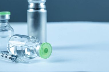 Vaccine in vial and syringe close-up on a white table gray background, medical concept, laboratory, subcutaneous injection vaccination, dose. Disease treatment immunization.