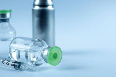 Vaccine in vial and syringe close-up on a white table gray background, medical concept, laboratory, subcutaneous injection vaccination, dose. Disease treatment immunization.