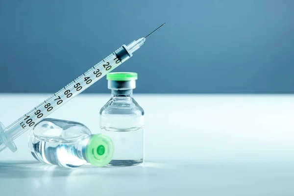 Вакцина у флаконі та шприці крупним планом на сірому фоні білого столу, медична концепція, лабораторія, вакцинація від підшкірних ін'єкцій, доза. Лікування хвороби імунізація . — стокове фото