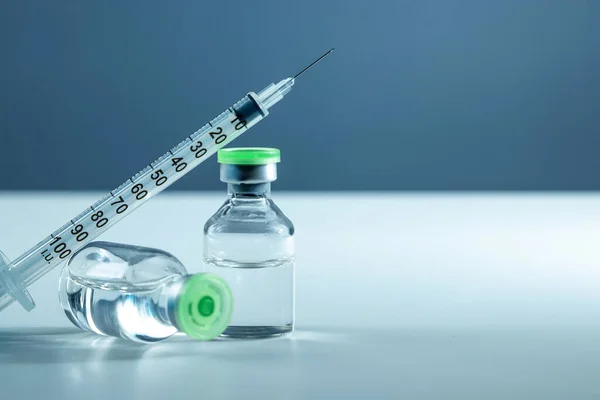 Вакцина у флаконі та шприці крупним планом на сірому фоні білого столу, медична концепція, лабораторія, вакцинація від підшкірних ін'єкцій, доза. Лікування хвороби імунізація . — стокове фото