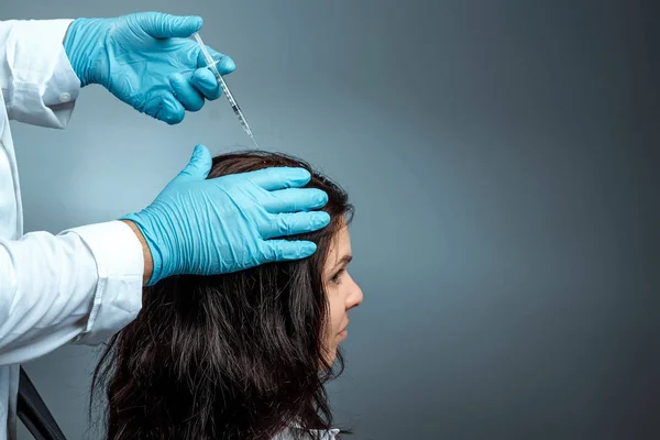 Вражаючи на зростання волосся, руки доктора Крупніпі Лана роблять ін'єкцію, впорскування в голову дівчини від втрати волосся. Здоров "я, догляд за тілом, спосіб життя. — стокове фото