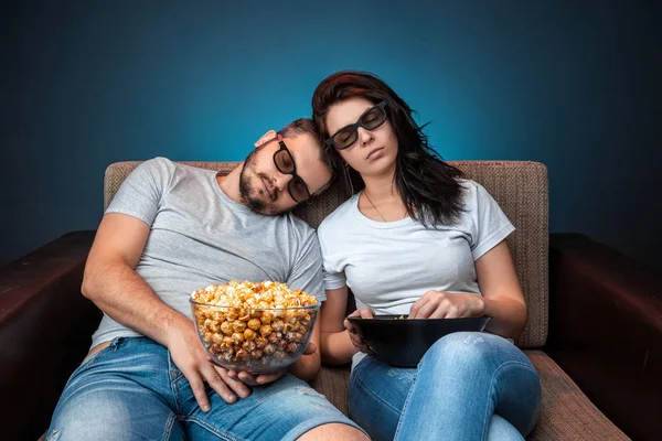 Un homme et une femme, une famille regardant un film ou une série en lunettes 3D, un fond bleu. Le concept de cinéma, films, émotions, surprise, loisirs, plateformes de streaming . — Photo